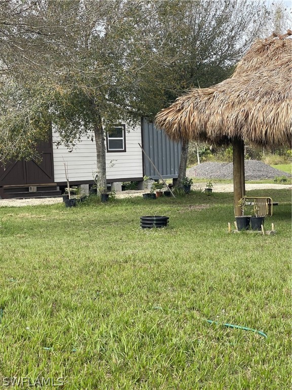13434 Tangelo Avenue Clewiston, FL 33440 - Photo 21 of 42 a backyard of a house with barbeque oven table and chairs