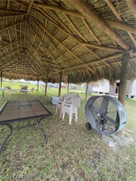 13434 Tangelo Avenue Clewiston, FL 33440 - Photo 22 of 42 a view of a backyard with table and chairs under an umbrella with a small yard