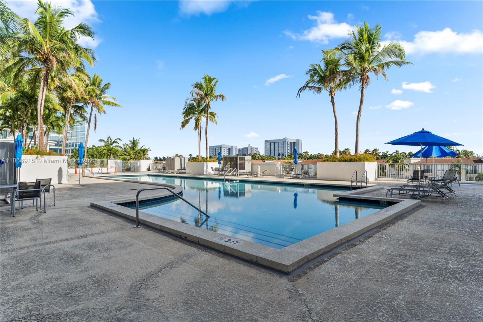 3029 Northeast 188th Street, Unit 924 Aventura, FL 33180 - Photo 15 of 20 a view of a swimming pool with a table and chairs