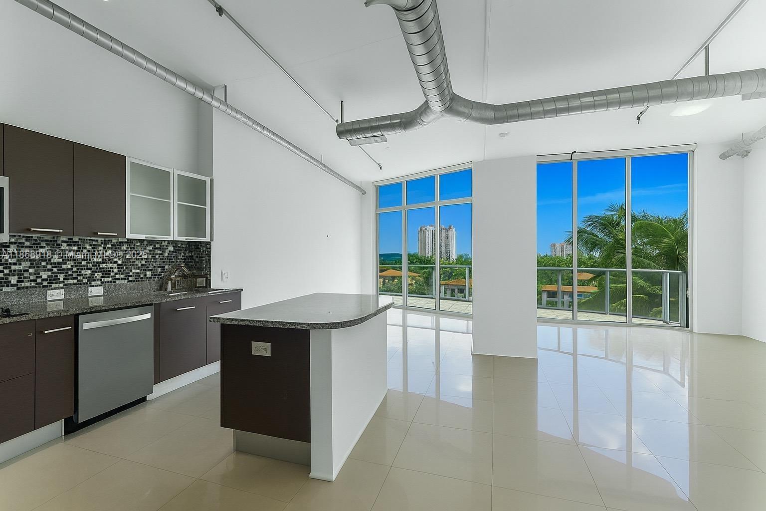 3029 Northeast 188th Street, Unit 924 Aventura, FL 33180 - Photo 20 of 20 a kitchen with stainless steel appliances granite countertop a sink and wooden cabinets