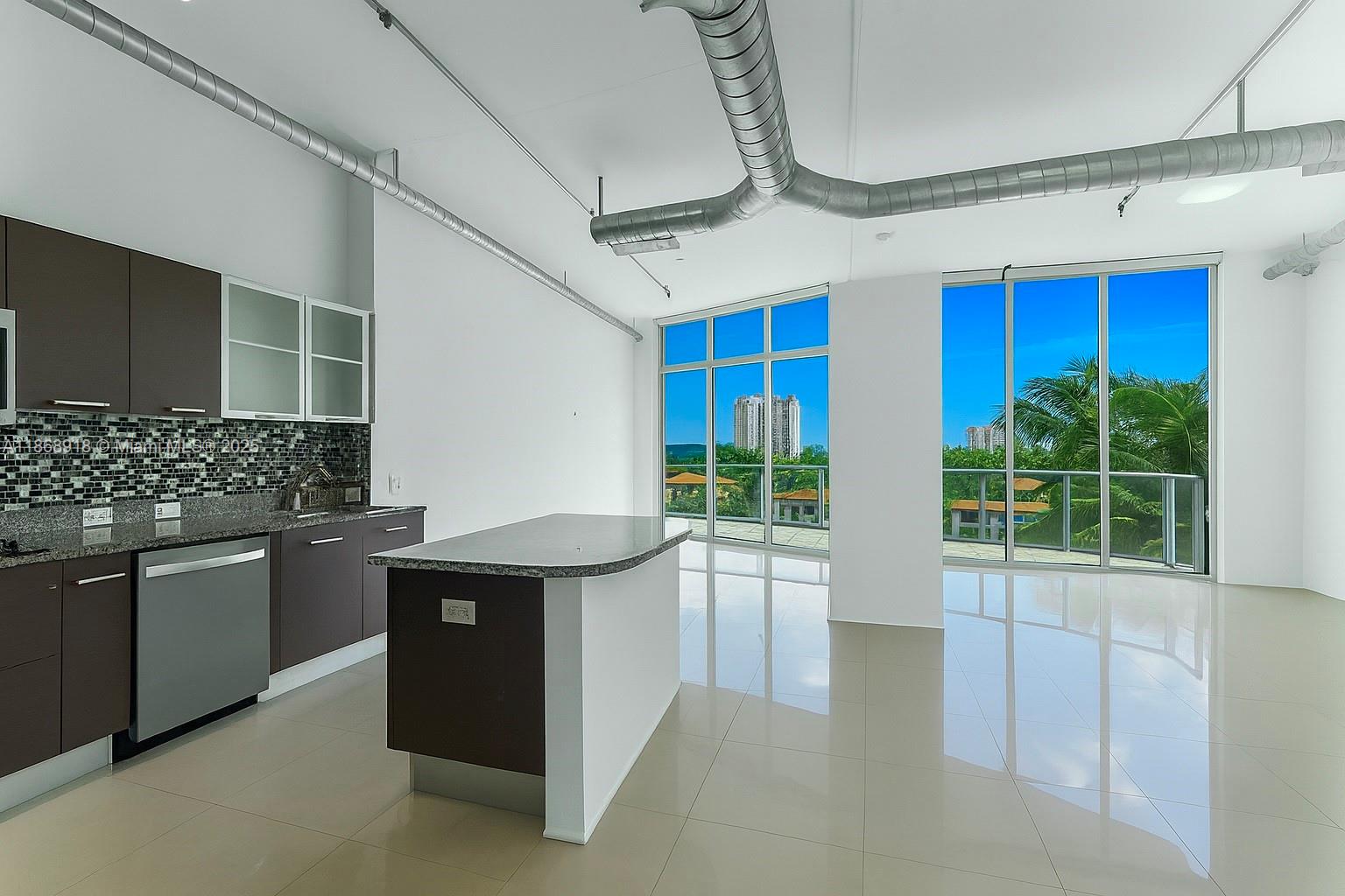 3029 Northeast 188th Street, Unit 924 Aventura, FL 33180 - Photo 2 of 20 a kitchen with stainless steel appliances granite countertop a sink and wooden cabinets