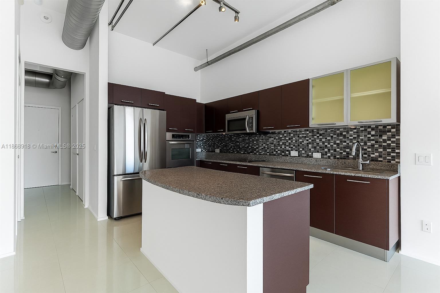 3029 Northeast 188th Street, Unit 924 Aventura, FL 33180 - Photo 3 of 20 a kitchen with stainless steel appliances granite countertop a sink stove and refrigerator
