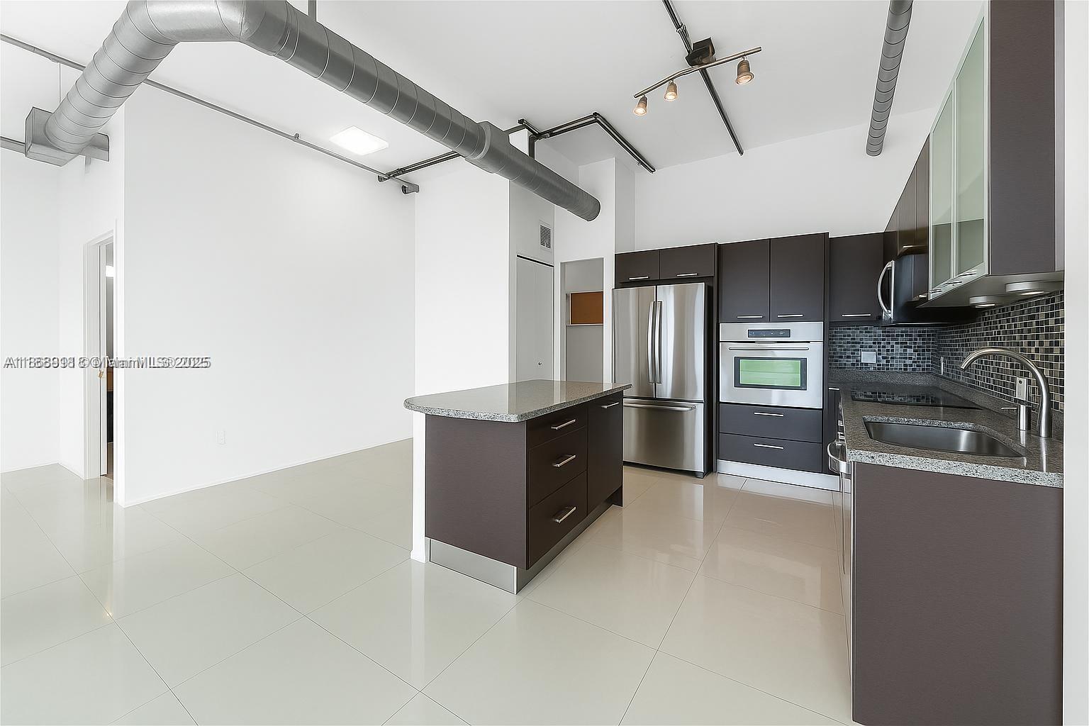 3029 Northeast 188th Street, Unit 924 Aventura, FL 33180 - Photo 4 of 20 a kitchen with stainless steel appliances granite countertop a refrigerator and a sink