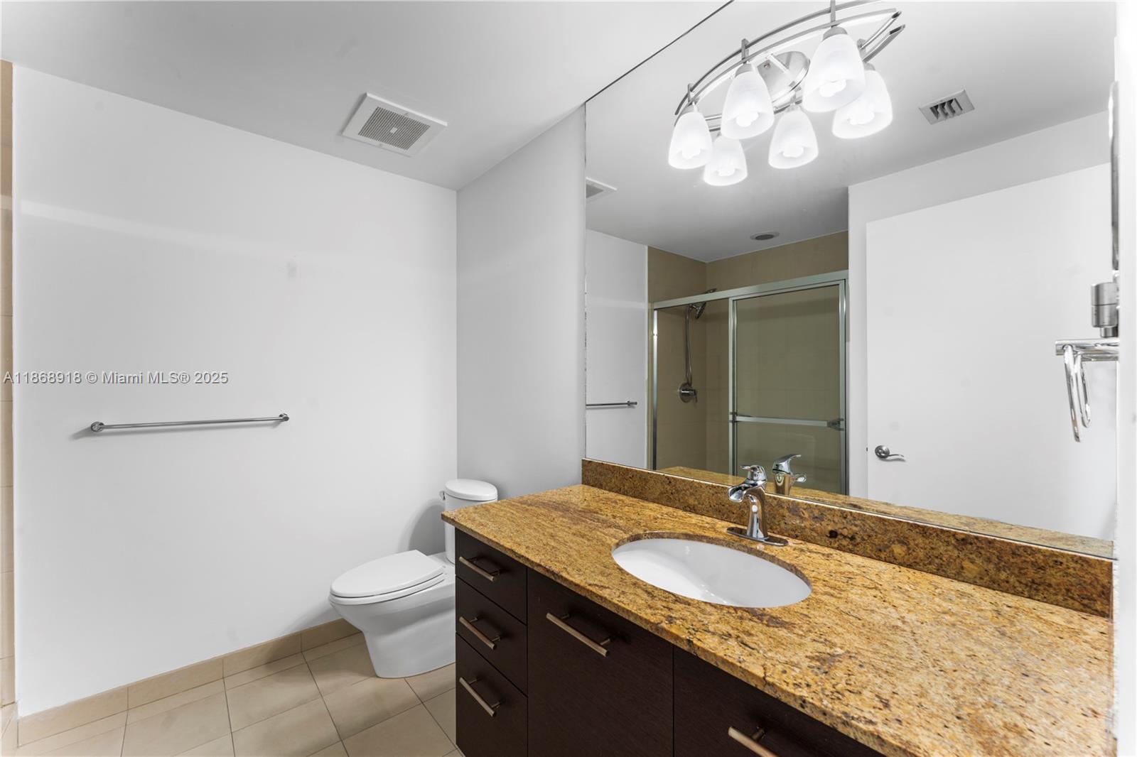 3029 Northeast 188th Street, Unit 924 Aventura, FL 33180 - Photo 5 of 20 a bathroom with a granite countertop sink a toilet and a mirror