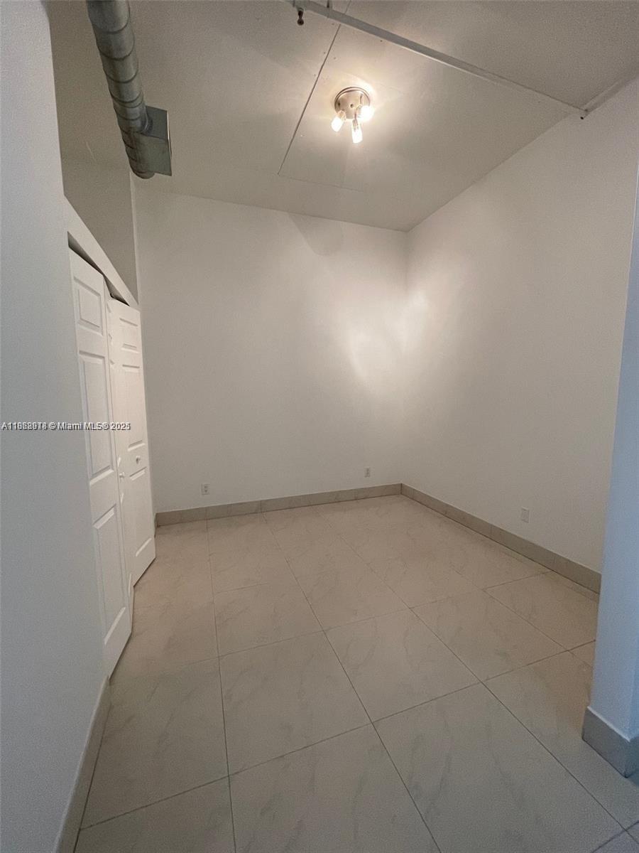 3029 Northeast 188th Street, Unit 924 Aventura, FL 33180 - Photo 9 of 20 an empty room with projector and cabinets