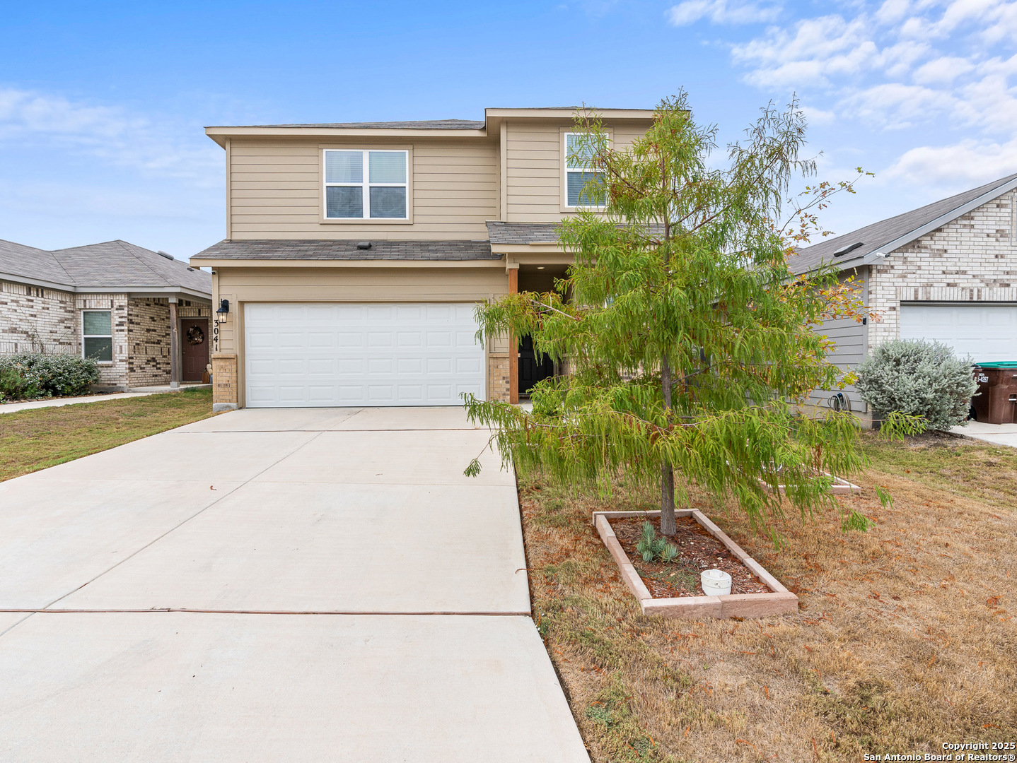 a front view of a house with a yard and garage