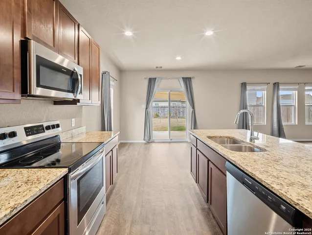 a kitchen with stainless steel appliances granite countertop a sink stove and refrigerator