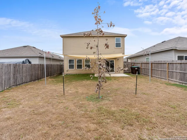 a view of a house with backyard and a tree