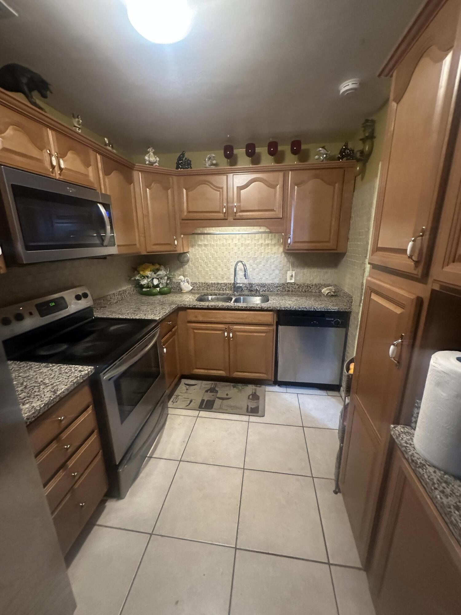 916 Caroline Avenue West Palm Beach, FL 33413 - Photo 3 of 14 a kitchen with granite countertop a stove a sink and a microwave