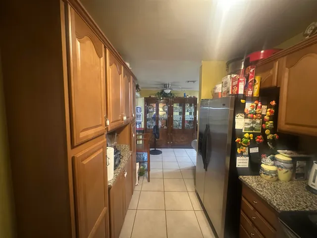 a hallway with painting on the wall and a potted plant