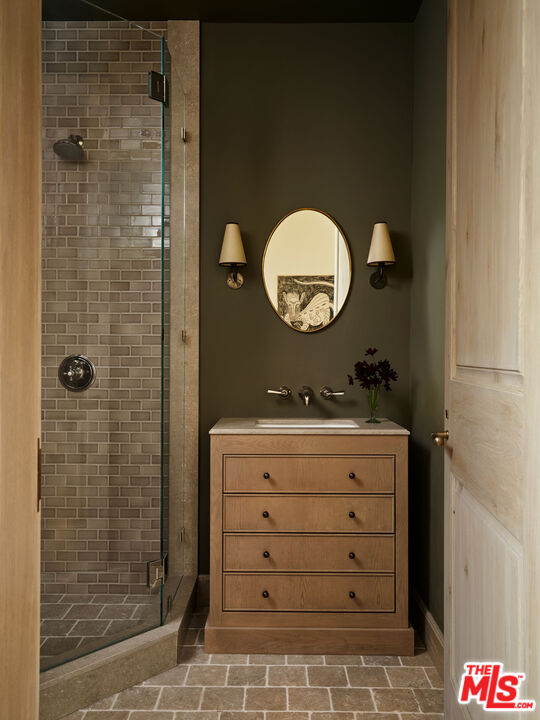 694 North Tigertail Road Los Angeles, CA 90049 - Photo 29 of 34 a bathroom with a granite countertop sink a mirror and shower
