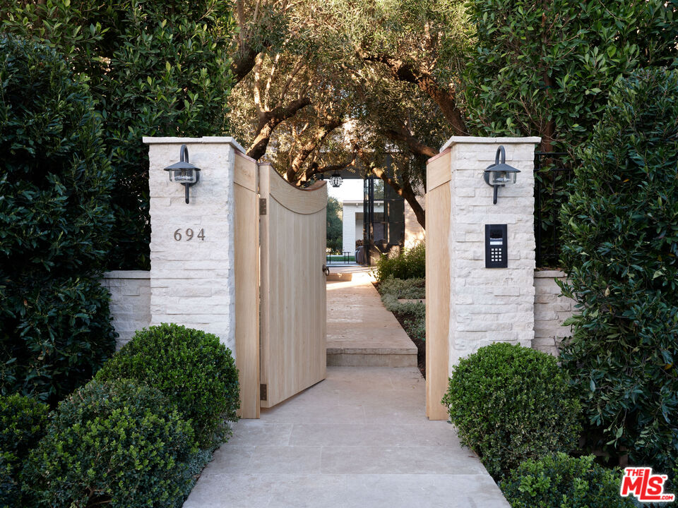 694 North Tigertail Road Los Angeles, CA 90049 - Photo 3 of 34 a pathway of a house with potted plants