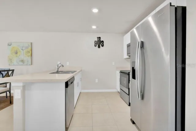 a kitchen with stainless steel appliances kitchen island granite countertop a refrigerator and microwave