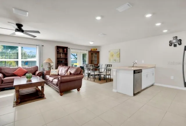 a kitchen with stainless steel appliances a refrigerator a sink a stove top oven a refrigerator and a window