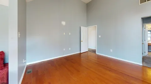 a view of an empty room with wooden floor