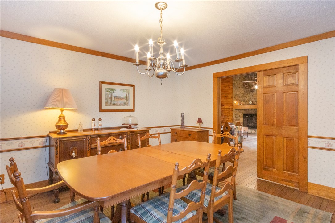 911 State Rd S-4-203 Belton, SC 29627 - Photo 15 of 49 A classic dining room, perfect for gathering, features a traditional chandelier and warm wood flooring.