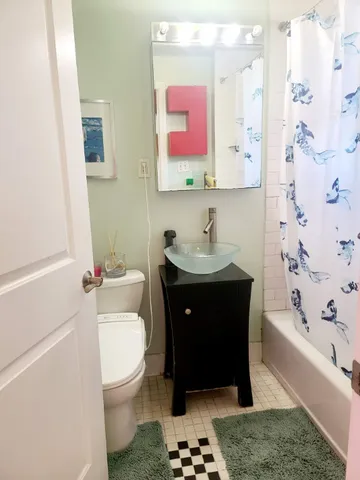 a bathroom with a sink a toilet and shower