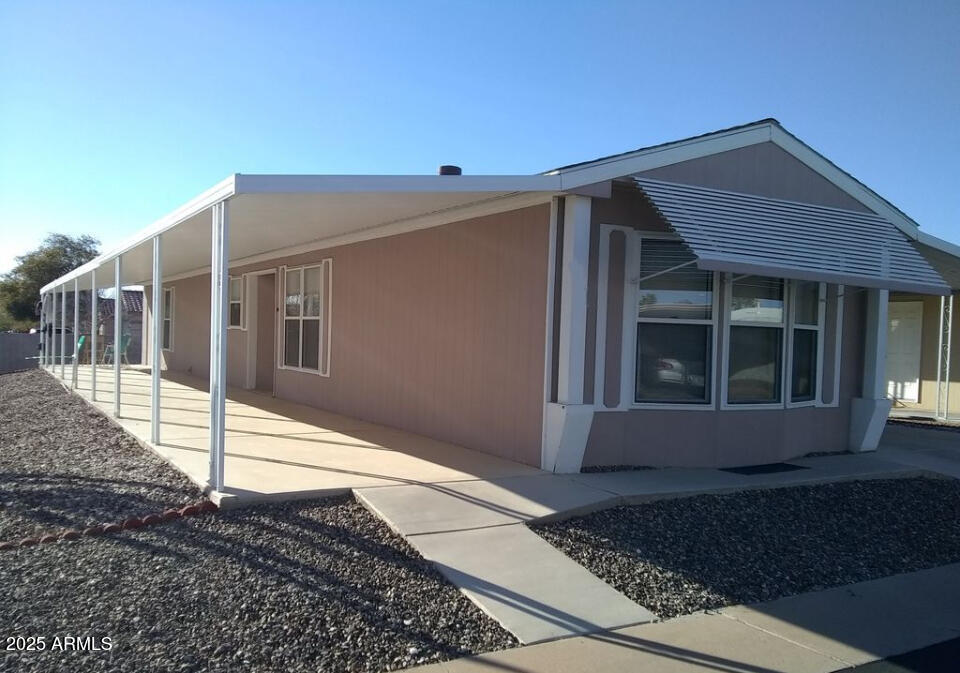834 South Meridian Road, Unit 173 Apache Junction, AZ 85120 - Photo 1 of 6 a view of a house with a small yard and wooden floor and fence