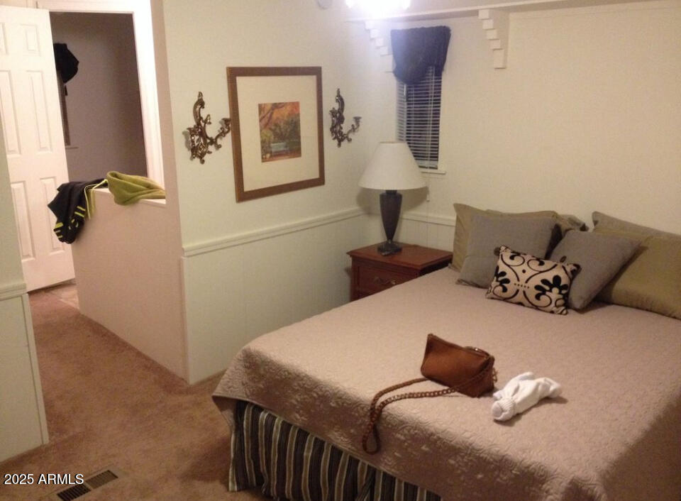 834 South Meridian Road, Unit 173 Apache Junction, AZ 85120 - Photo 2 of 6 a bedroom with a bed and wooden floor