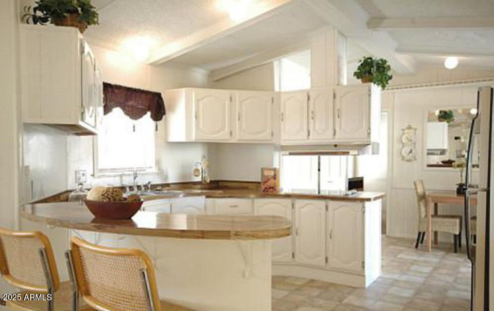 834 South Meridian Road, Unit 173 Apache Junction, AZ 85120 - Photo 4 of 6 a kitchen with stainless steel appliances granite countertop a sink a stove and a refrigerator