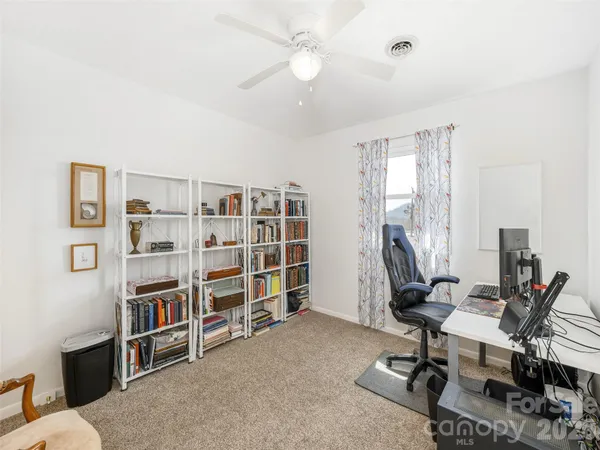 a view of a room with furniture and a ceiling fan