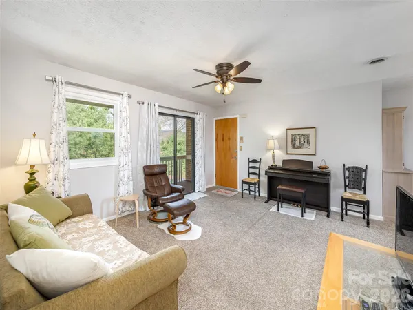 a living room with furniture a piano and a flat screen tv