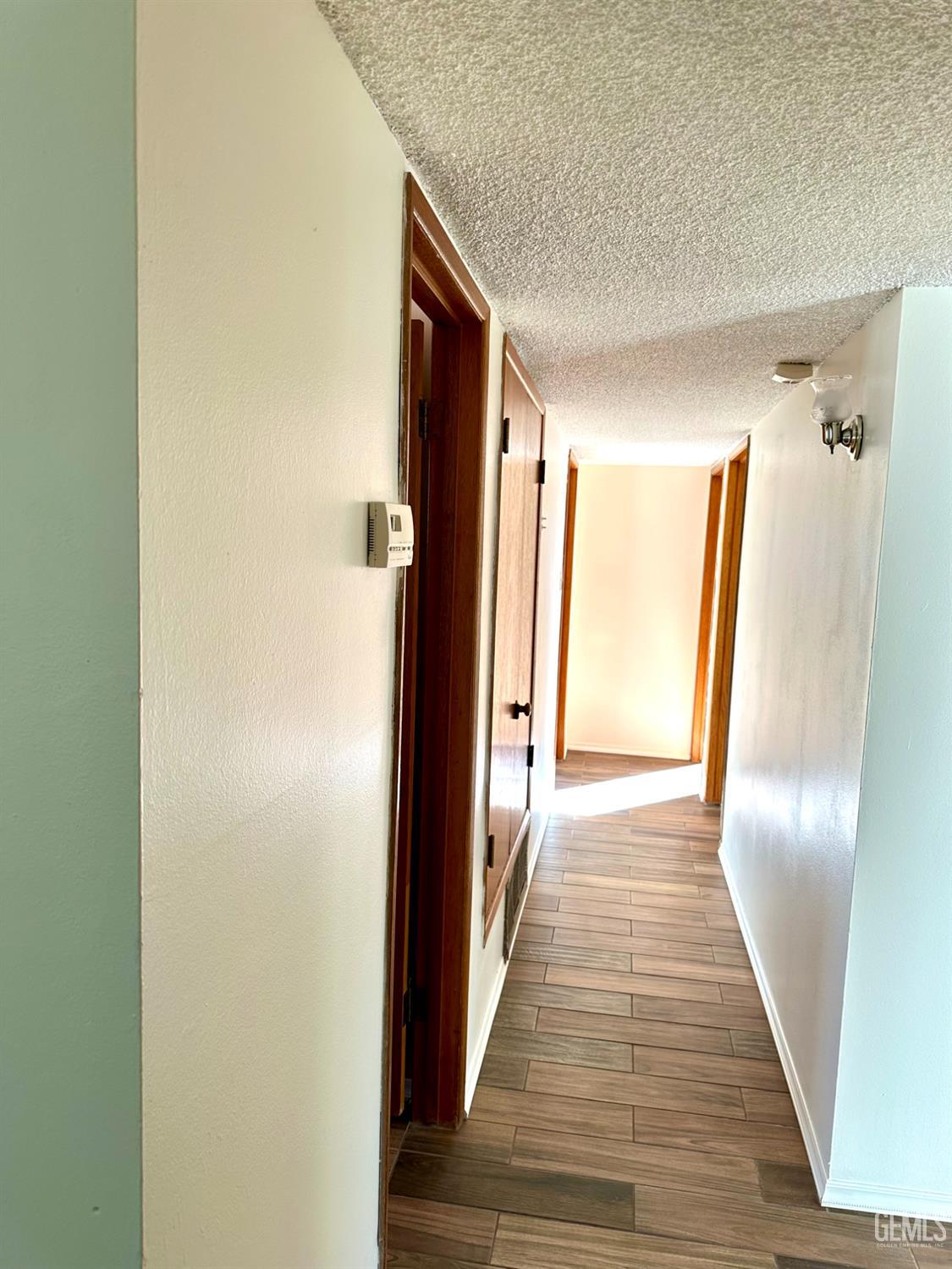 Undisclosed Address Delano, CA 93215 - Photo 2 of 14 a view of a hallway with wooden floor and staircase