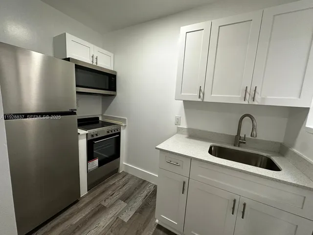 a kitchen with a refrigerator and a sink