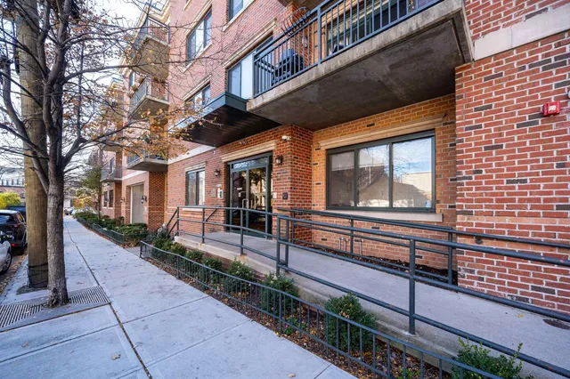 a view of a house with a small yard and a large tree