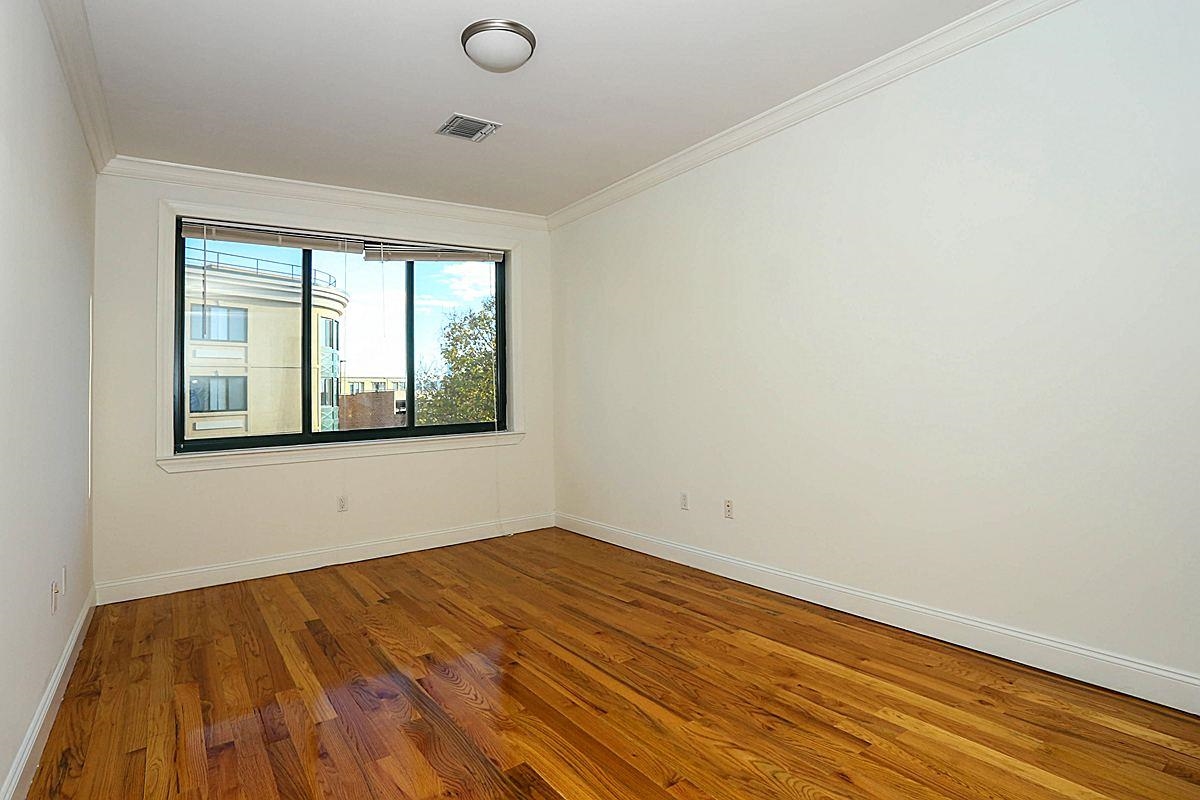 85 Maple Street, Unit 2L Weehawken, NJ 07086 - Photo 3 of 11 wooden floor in an empty room with a window