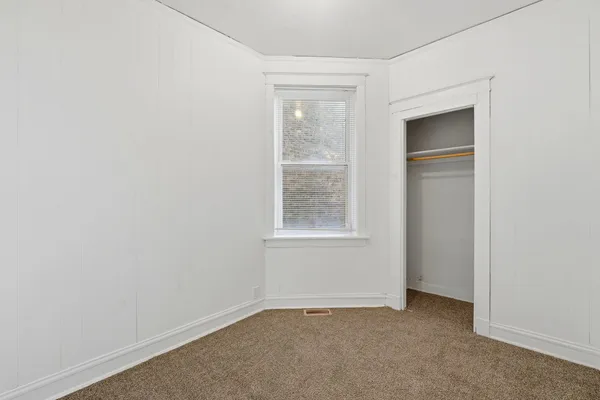 an empty room with windows and closet