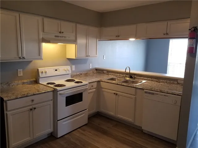 a kitchen with a sink stove and cabinets