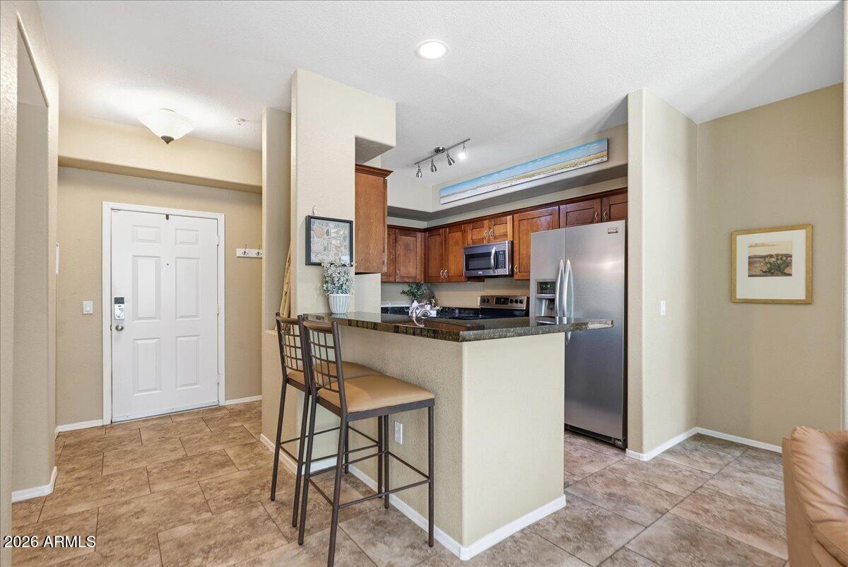 435 West Rio Salado Parkway, Unit 111 Tempe, AZ 85281 - Photo 7 of 44 a kitchen with stainless steel appliances kitchen island granite countertop a refrigerator and cabinets