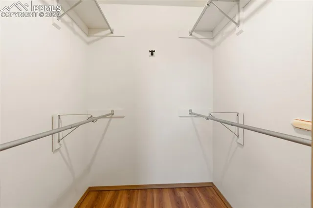 a view of walk in closet with racks on the wall