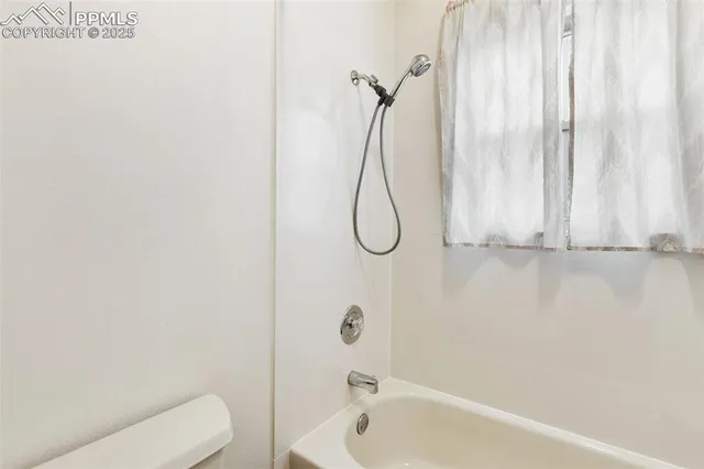 a bathroom with a bath tub with a shower curtain