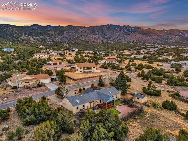 an aerial view of residential houses with outdoor space and trees