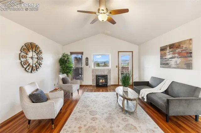 a living room with furniture a fireplace and a large window