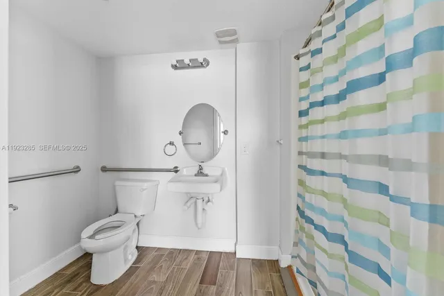 a bathroom with a toilet and a shower curtain