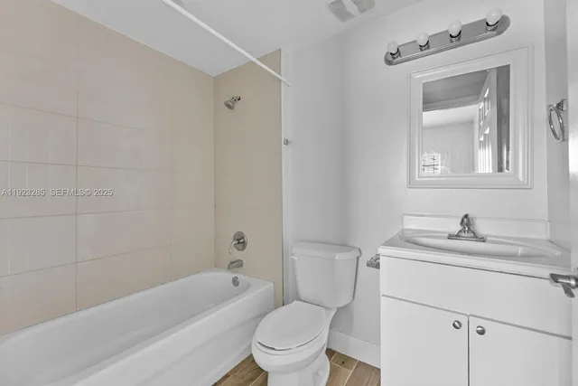 a bathroom with a sink toilet vanity granite tub and shower