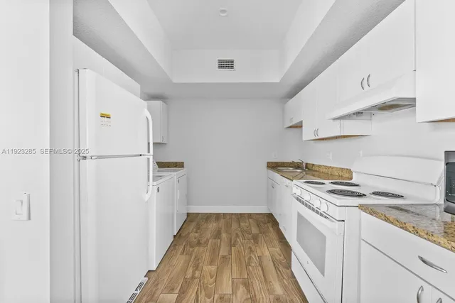 a kitchen with white cabinets and white appliances