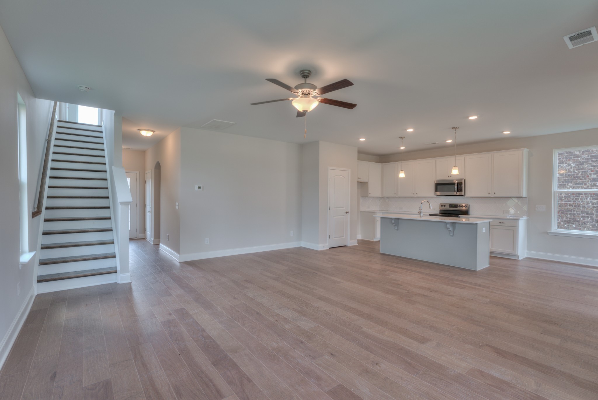 9012 Headwaters Drive Franklin, TN 37064 - Photo 6 of 25 a view of an empty room and kitchen with wooden floor