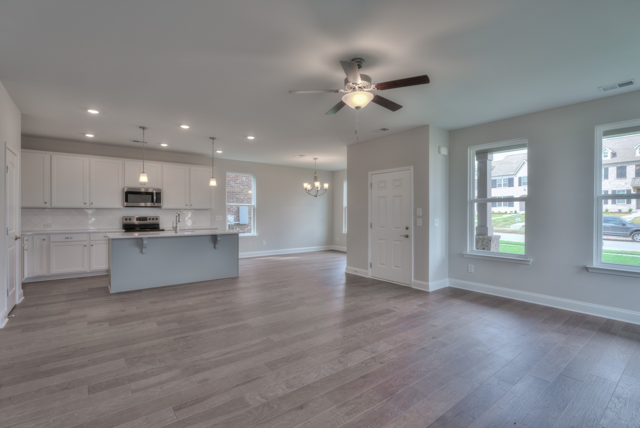 9012 Headwaters Drive Franklin, TN 37064 - Photo 7 of 25 a view of an empty room and kitchen with wooden floor and window