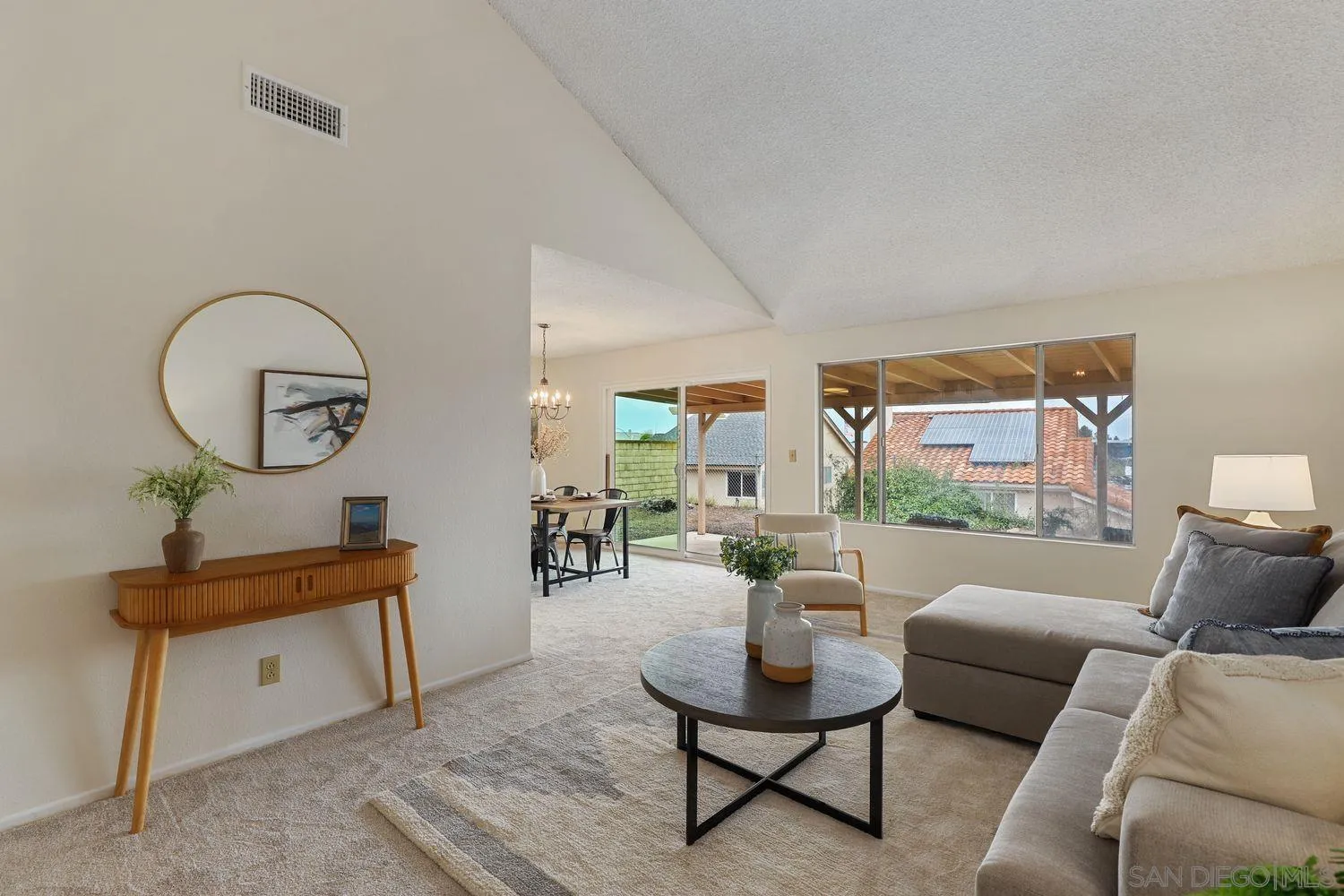 a living room with furniture a mirror and a potted plant
