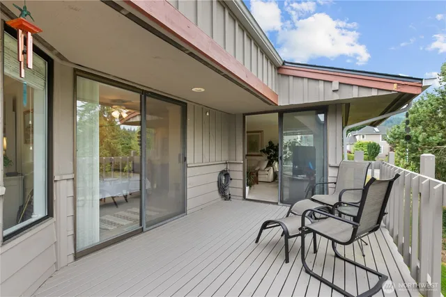 a view of a patio with table and chairs with wooden floor and fence