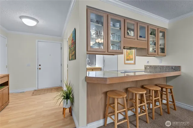 a kitchen with stainless steel appliances granite countertop a table chairs in it and wooden floor