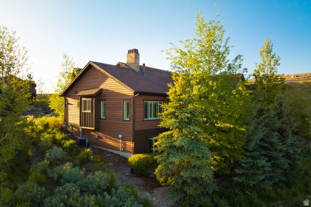 1737 East Viewside Circle Hideout, UT 84036 - Photo 31 of 35 Brown siding exterior with a dark shingle roof, a brick chimney, and a bay window