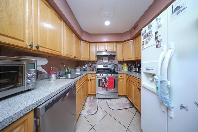 a kitchen with stainless steel appliances granite countertop a stove a sink and a microwave