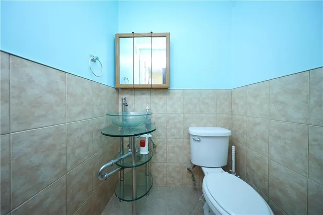 a bathroom with a toilet a sink and mirror