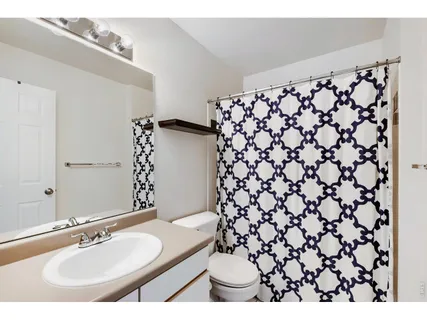a bathroom with a sink and a mirror with shower curtain