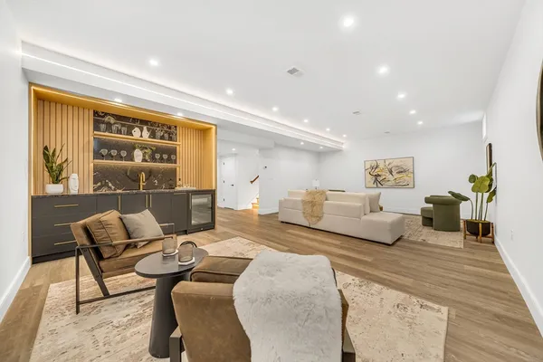 a living room with furniture wooden floor and a window